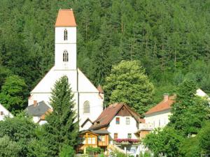 eine große weiße Kirche mit einem Turm vor einem Berg in der Unterkunft Apartments Am Kirchkogel "Ländliche Entspannung im Herzen der Steiermark" in Pernegg an der Mur