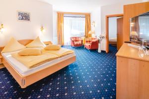 a hotel room with a bed and a living room at Hotel Andrea 3-Sterne Superior in Gerlos