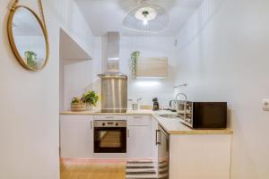 a white kitchen with a sink and a microwave at Le Bel-Air - Plage à 700 m - St Malo in Saint Malo