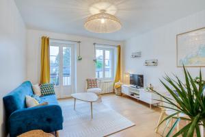 a living room with a blue couch and a tv at Le Bel-Air - Plage à 700 m - St Malo in Saint Malo