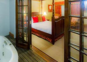 
a bedroom with a bed and a mirror at Audacia Manor Boutique Hotel in Durban
