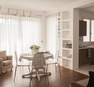 a white dining room with a table and chairs at La Casa di Giò in Caorle