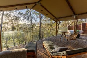 a screened in porch with a table and a chair at Currajong Retreat in Burragate