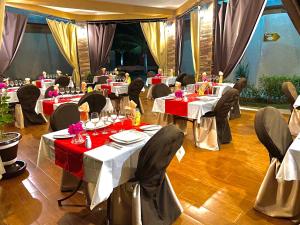 a banquet hall with tables with red and white table settings at Hôtel La Belle Etoile & SPA in Saly Portudal