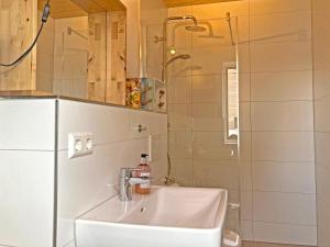 uma casa de banho com um lavatório e um frigorífico em Zum Seglerhafen – Ferienappartement em Kressbronn am Bodensee