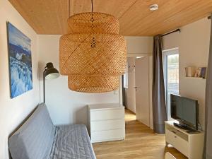 a living room with a chandelier and a tv at Zum Seglerhafen – Ferienappartement in Kressbronn am Bodensee