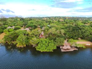 an island with trees and a house in the water at Nhambavale Lodge in Chidenguele