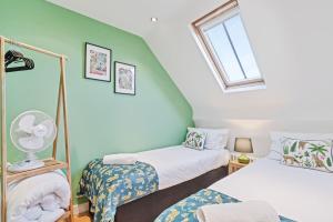 a room with two beds and a window at Majestic Mews Apartment with Free Parking - By My Getaways in Brighton & Hove