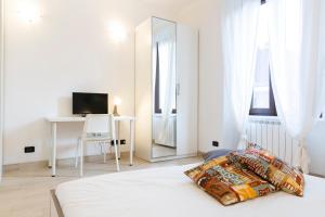 a white bedroom with a bed and a mirror at Affori 4ever - 2 bedrooms in Milan