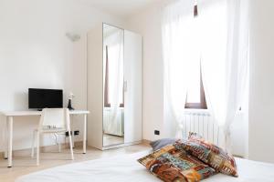 Dormitorio blanco con espejo y cama en Affori 4ever - 2 bedrooms, en Milán
