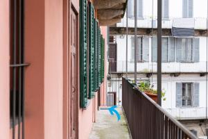 un callejón entre dos edificios con un pájaro azul en un balcón en Affori 4ever - 2 bedrooms, en Milán