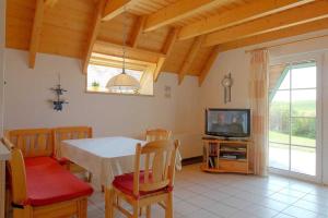 a dining room with a table and a television at Strandvogt 2 HA29 in Schottwarden