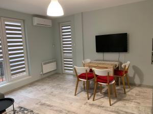 a dining room with a table and chairs and a flat screen tv at Апартамент Сливен in Sliven