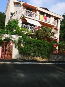um edifício branco com varandas e plantas numa rua em Villa Maja em Omišalj