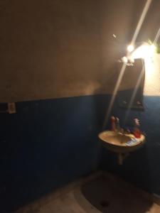 a bathroom with a sink and a light on the wall at Suit compartida con amenidades in Mexico City +10 photos
