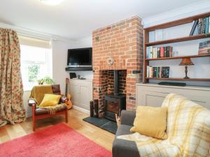 ein Wohnzimmer mit einem gemauerten Kamin und einem TV in der Unterkunft 21 Florence Road in Lowestoft