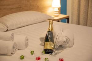 a bottle of champagne and a glass on a bed at Romerooms in Rome