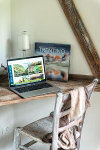 un computer portatile seduto su una scrivania in legno con sedia di Berry House a Vigolo Vattaro