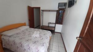 a small bedroom with a bed with two white shoes on it at Pousada do caju in Serra