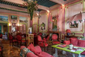 - un salon avec des chaises rouges et une cheminée dans l'établissement Demeure de Digoine "Chambre d'Hotes", à Bourg-Saint-Andéol