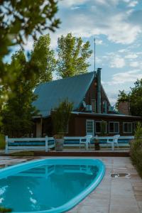 una casa con piscina frente a una casa en Villa Ciruelos en San Rafael