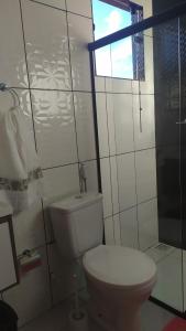 a white bathroom with a toilet and a window at Pousada Mirante Das Serras Ibicoara-BA in Ibicoara +15 photos