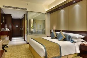 a bedroom with a large bed and a bathroom at Crowne Plaza Ahmedabad City Centre, an IHG Hotel in Ahmedabad