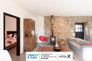 ein Wohnzimmer mit einem Sofa und einem Kamin in der Unterkunft Quinta Olivia in Ponte da Barca