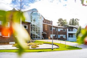 un bâtiment en briques avec un bâtiment en verre dans l'établissement Spa Hotel Härmä - Härmän Kylpylä, à Ylihärmä