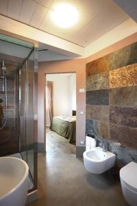 a bathroom with a sink and a shower and a bed at Tenuta Santi Giacomo e Filippo in Urbino