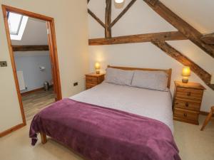 a bedroom with a large bed with a purple blanket at The Gallery in Craven Arms