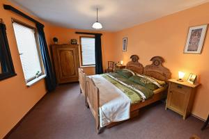 ein Schlafzimmer mit einem großen Bett mit orangefarbenen Wänden in der Unterkunft Chalupa u kostela in Chřibská