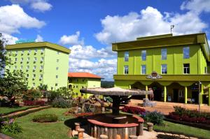 two buildings with a garden in front of a building at United Hotel in Mbankomo