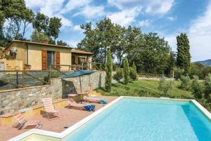 een zwembad met stoelen en een huis bij Villa Le Vignacce in Lustignano