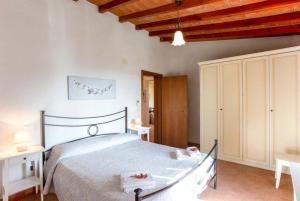 een slaapkamer met een groot bed en een houten plafond bij Villa Le Vignacce in Lustignano