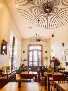 un ristorante con tavoli e sedie e un grande soffitto di L'Adresse Hôtel Boutique a Buenos Aires