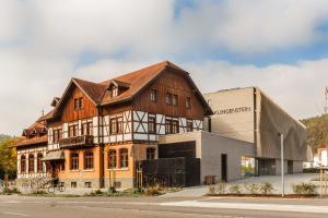 Klingenstein AKZENT Hotel Wirtshaus Brauerei في بلاوشتاين: مبنى خشبي كبير بجوار مبنى