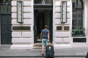 a man walking into a building with a suitcase at Hotel Rum Budapest in Budapest