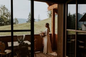 a bride standing on a porch with a bouquet at Mountain Chalet Pia in La Valle