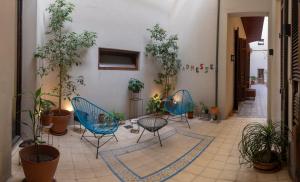 two chairs and a table in a hallway with plants at L'Adresse Hôtel Boutique in Buenos Aires