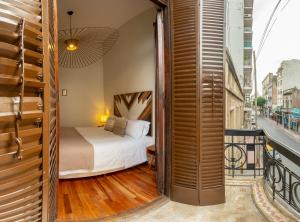 ブエノスアイレスにあるL'Adresse Hôtel Boutiqueのベッドとバルコニー付きのホテルルーム