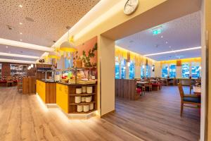 a restaurant with a counter and tables and a clock at Familotel Mein Krug in Warmensteinach