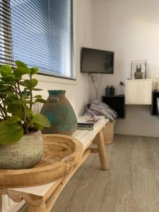 een woonkamer met een tafel met vazen erop bij Huisje 16 in Noordwijk aan Zee