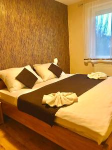 a large bed in a bedroom with a window at Barki Apartman in Bük