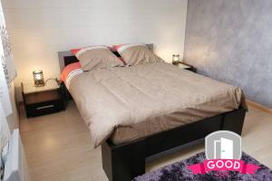 a bedroom with a large bed with a pink sign on it at Le Micy - joli T2 + Parking in Orléans