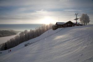 a ski lodge on a snow covered slope with the sun setting at Malskaya Dolina in Rogovo