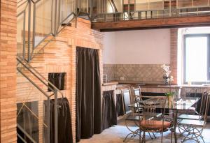 a room with a table and chairs and a brick wall at Morgan Suite Roma in Rome