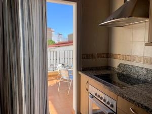 a kitchen with a view of a balcony with a table at Apartamentos Nerjaluna in Nerja