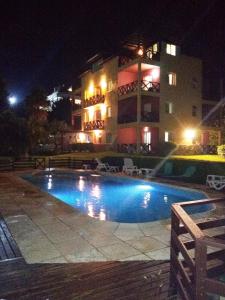 una piscina frente a un edificio por la noche en Carilo Quimey en Cariló