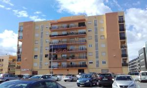 a tall building with cars parked in a parking lot at CENTRICO LABRADORES 15 in Peniscola